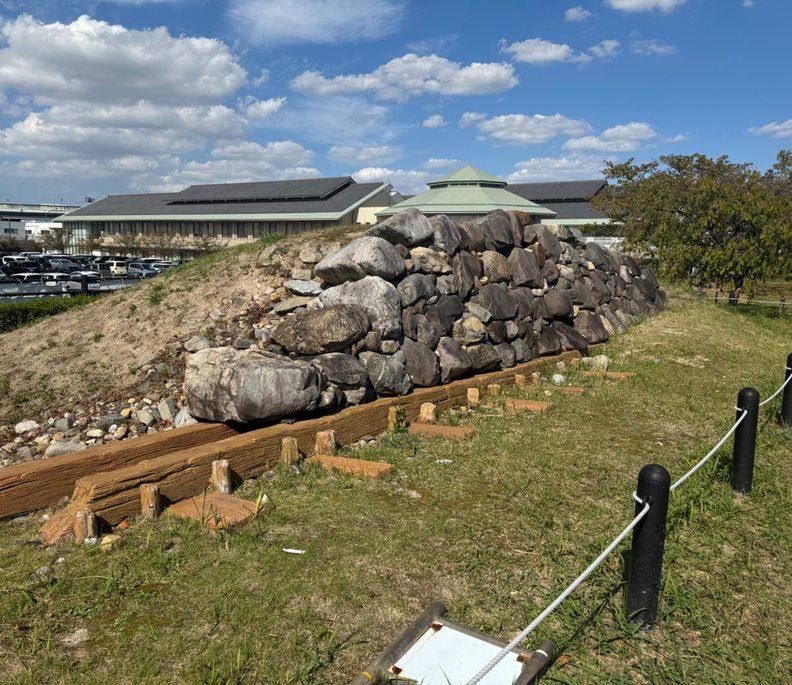 Displayed stone wall foundations at Kiyosu, with the modern castle building behind