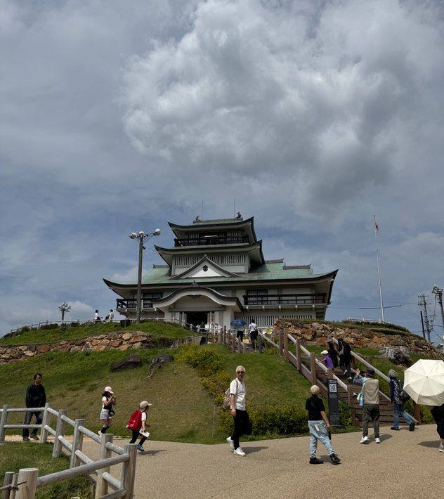 The castle-style museum at the summit of Komakiyama with visitors on the path