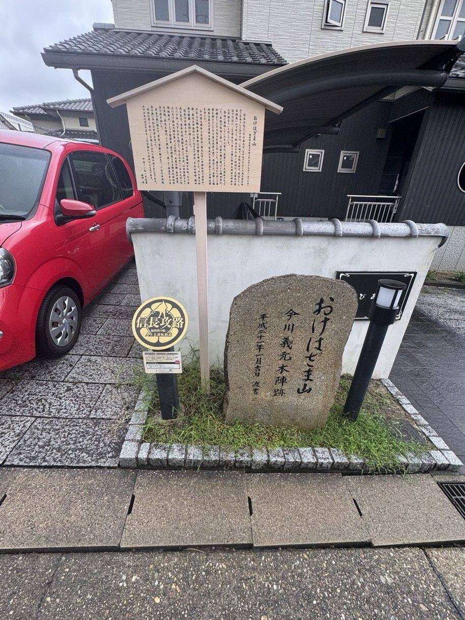 Okehazama-yama memorial stone and signboard beside houses